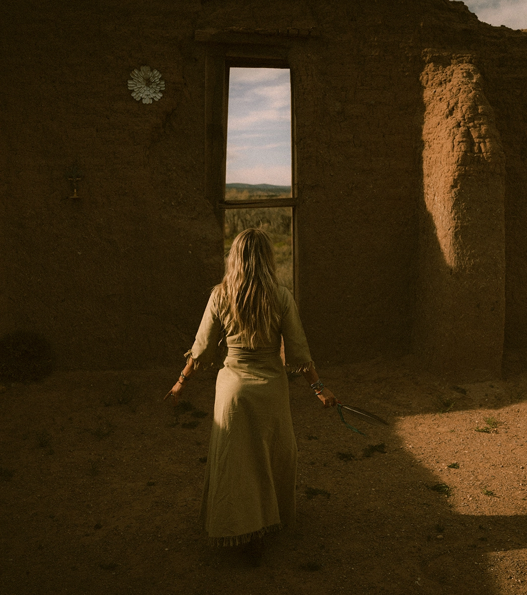 Woman walks to a mysterious door in the desert
