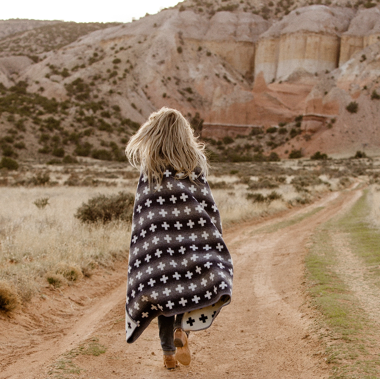 Woman walks towards beautiful rocks in a desert