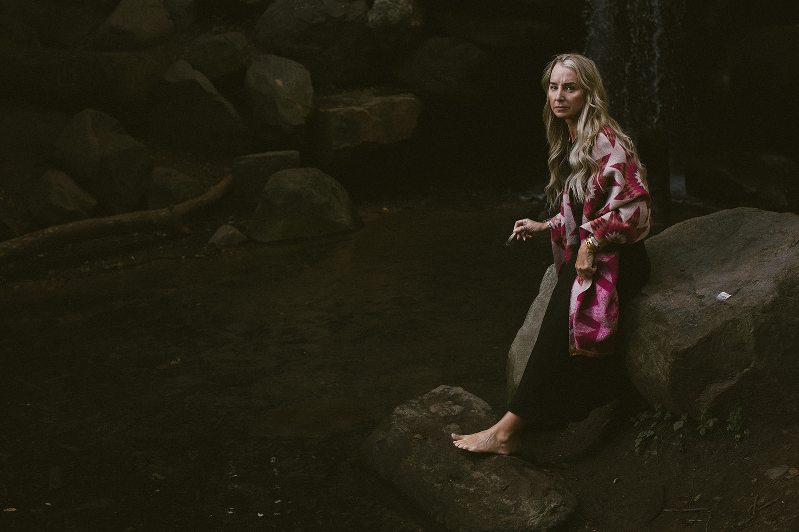 A woman in white dress walks through a desert