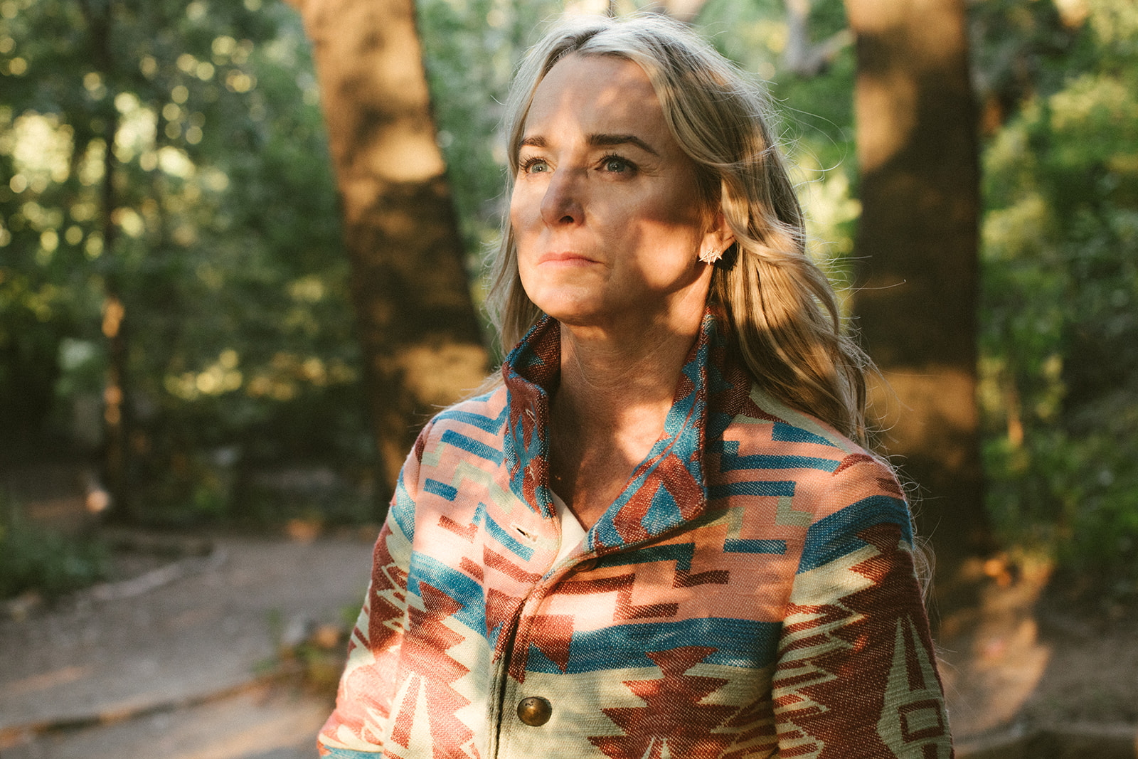Jennifer meditates with her eyes closed holding a feather in her hand