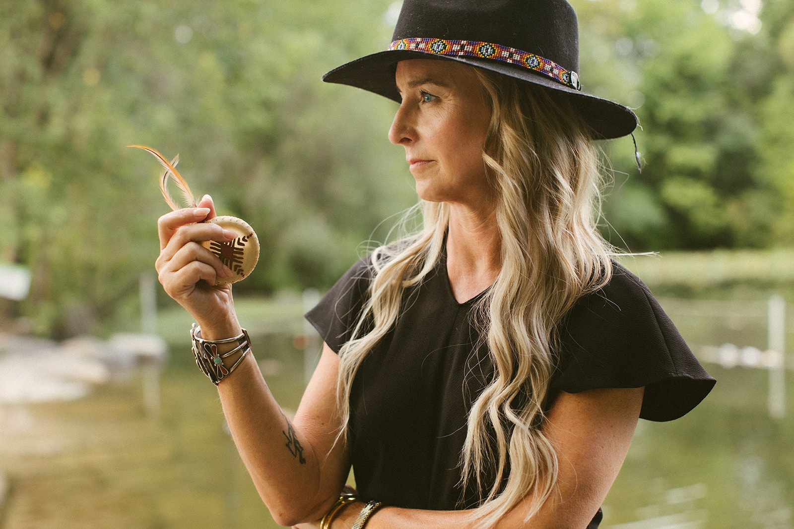 Jennifer meditates with her eyes closed holding a feather in her hand